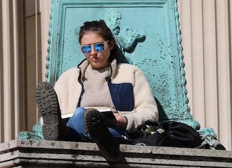 Student reading on steps of Low Library, Columbia University